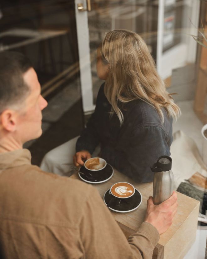 stainless steel reusable water bottle on table in a cafe 